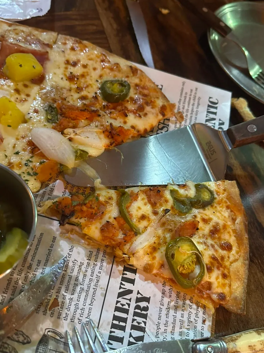 Sepotong pizza Hawaiian dengan topping nanas