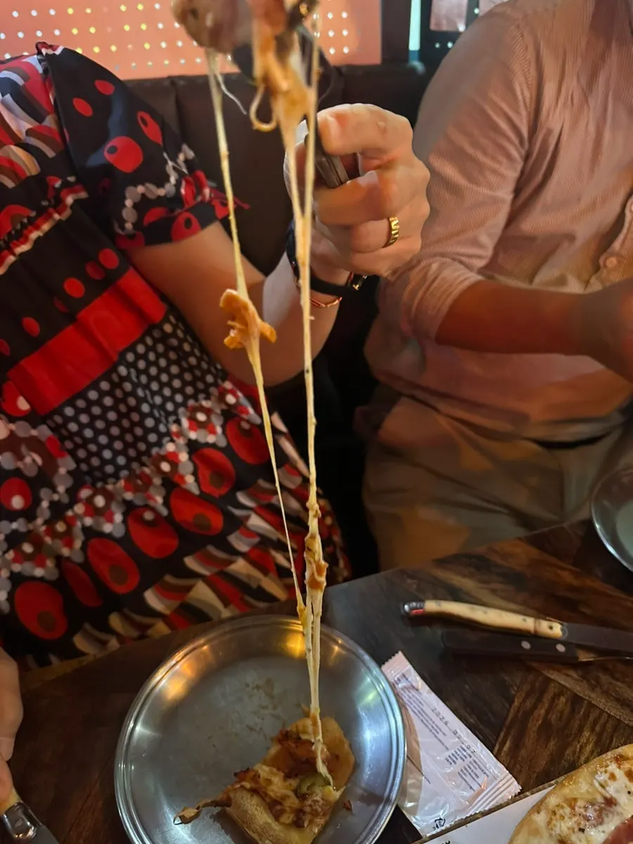 Sepotong pizza thin dough Spicy Chicken yang gurih dan sedikit pedas