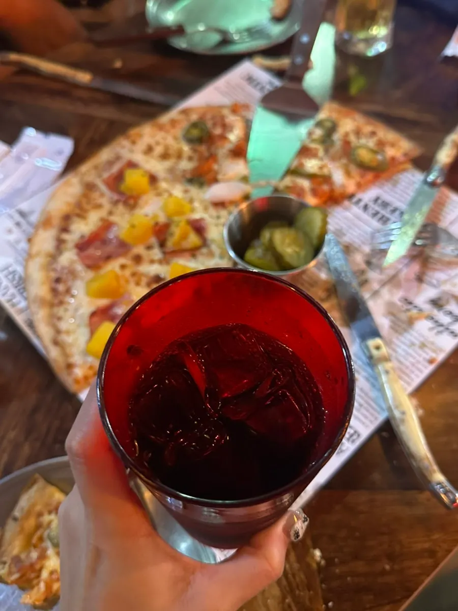 Sepotong pizza thin dough dengan keju yang molor