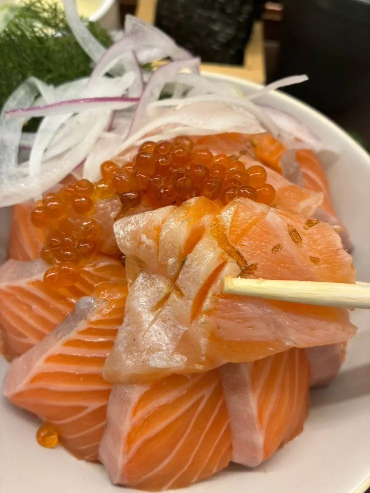 A bite of salmon sake-don with salmon roe
