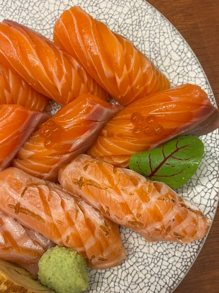 A piece of salmon sushi eaten without soy sauce