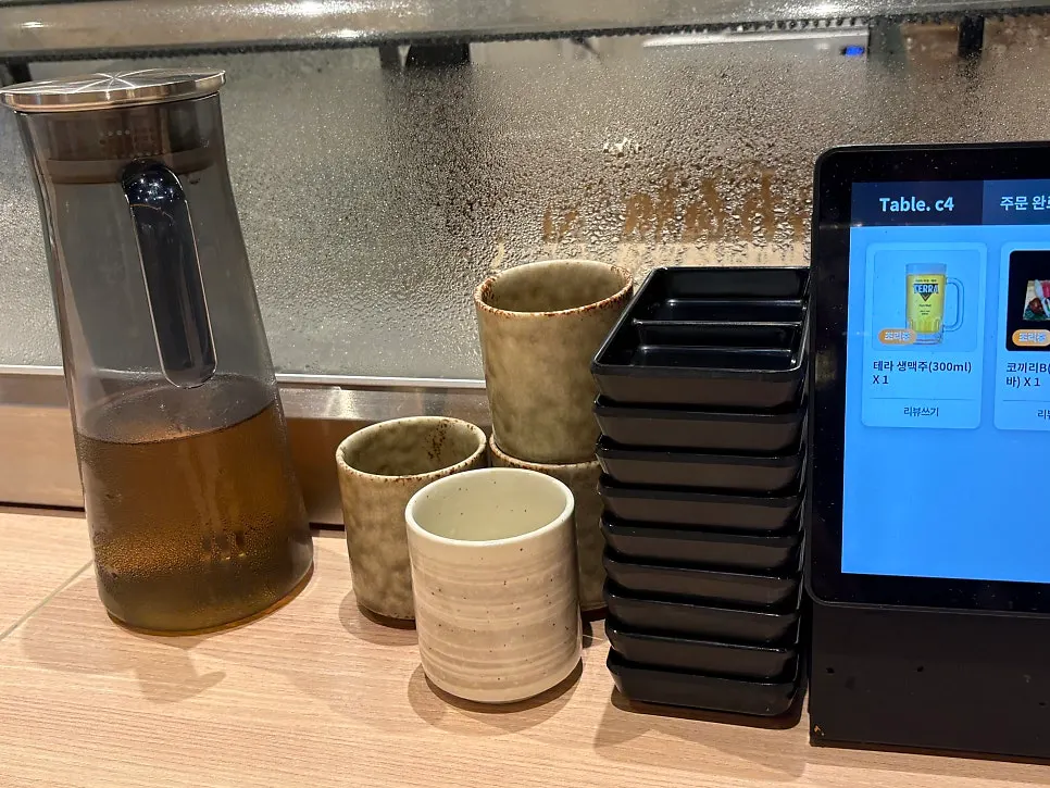 Water, soy sauce, and pickled radish set out at the counter seat