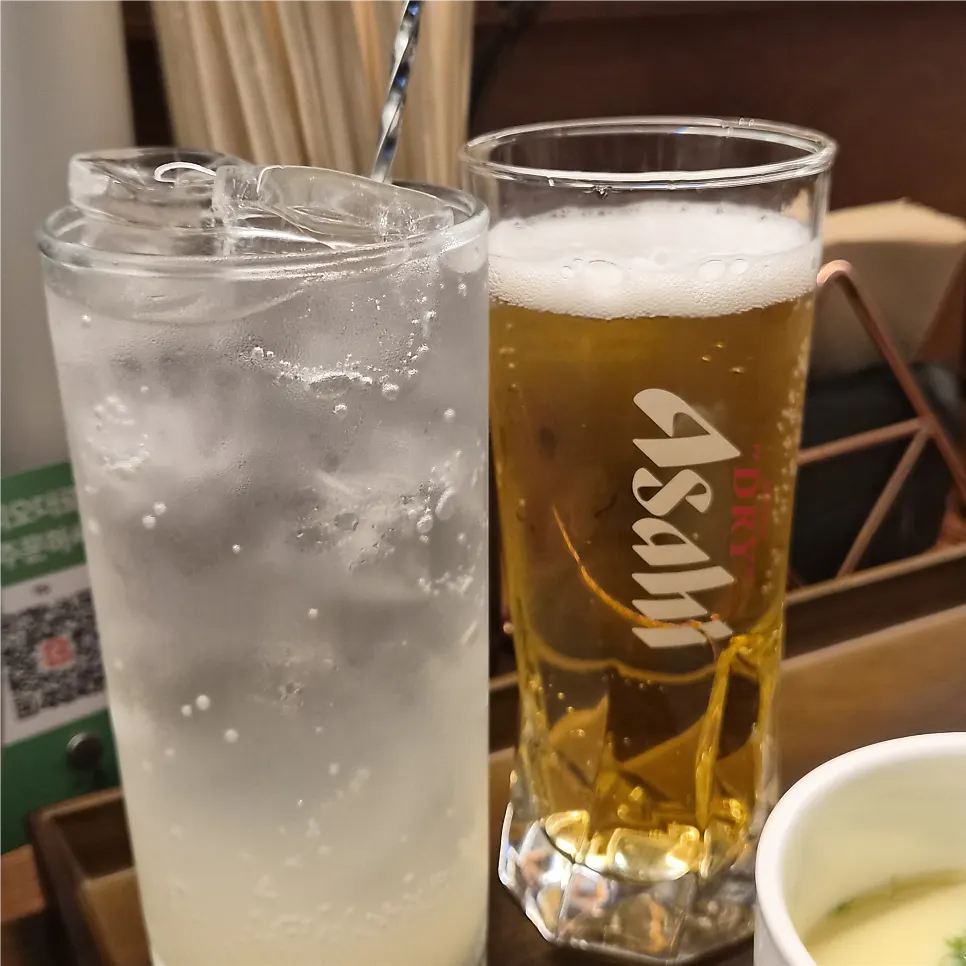 Half roll of futomaki with beer and a highball