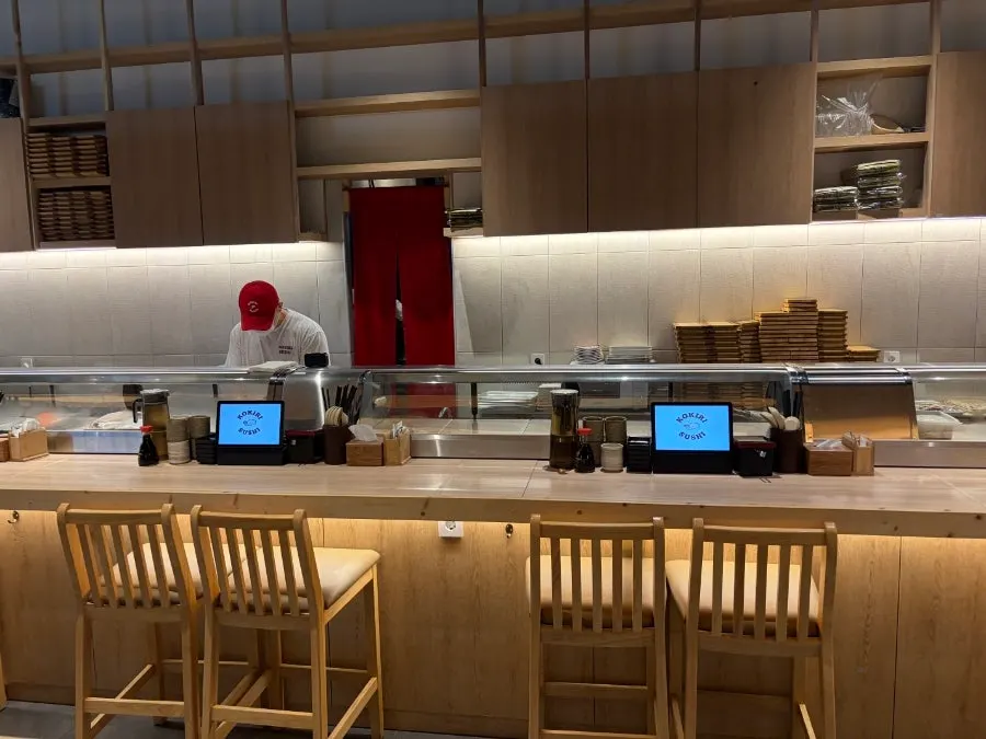 Interior view showing the open kitchen and counter seats