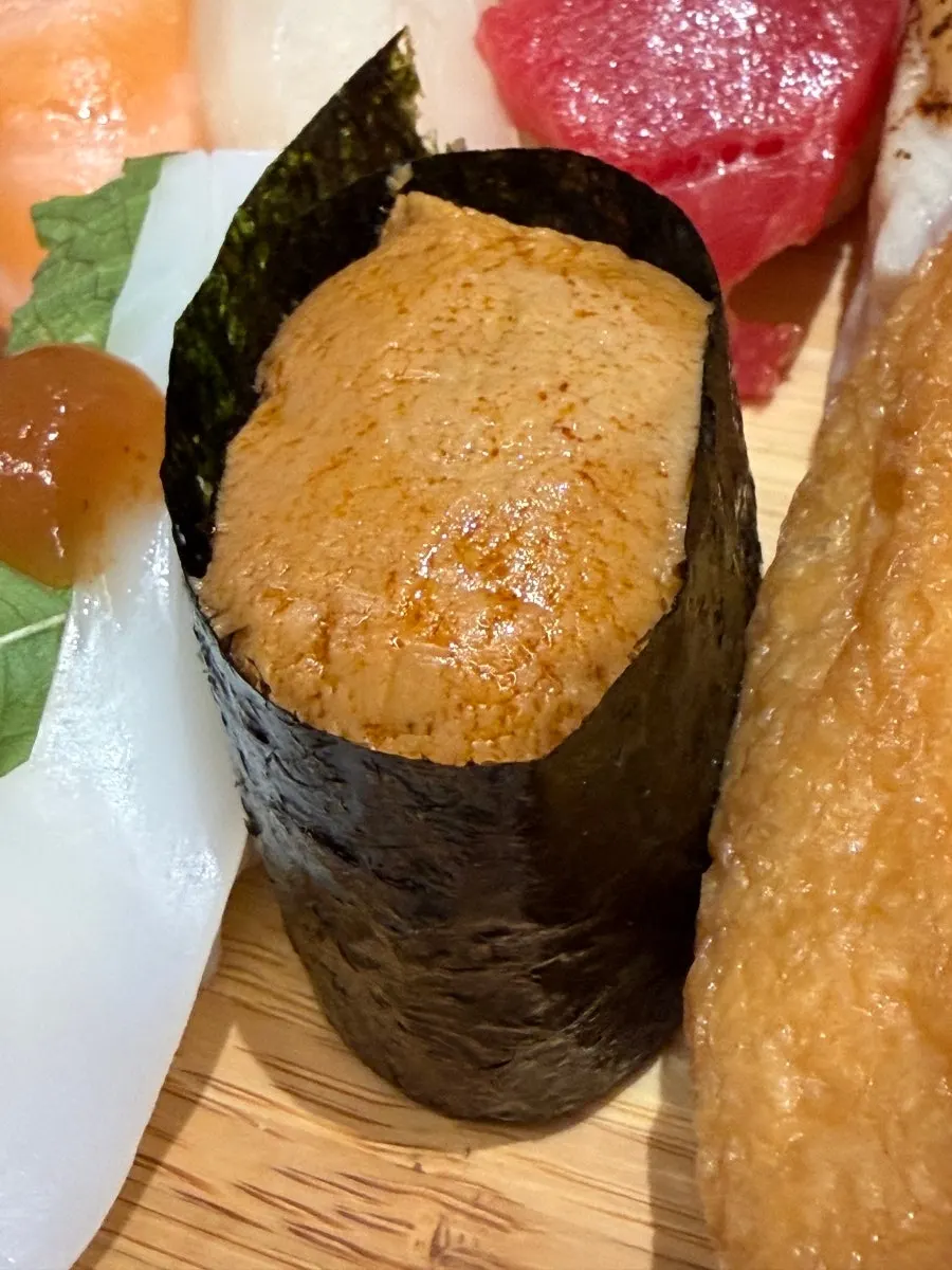 Squid sushi topped with a bright sauce dot