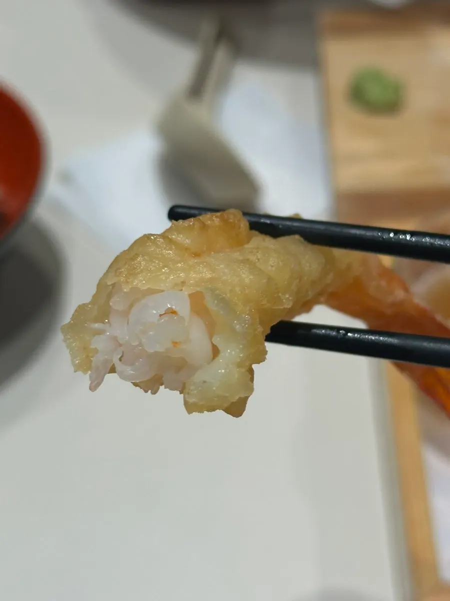 A bite taken out of the plump shrimp tempura