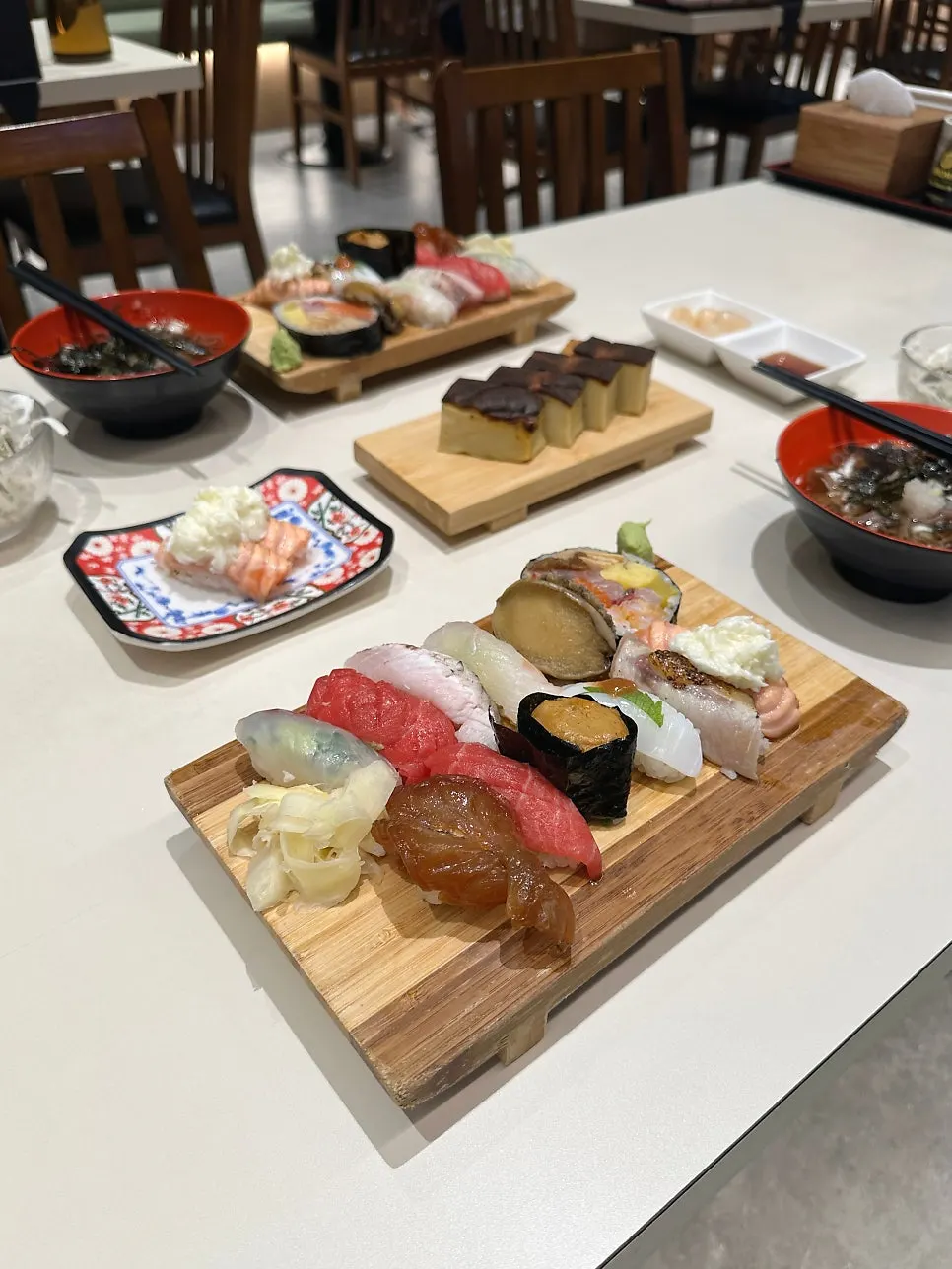 12 pieces of sushi served on a wooden board