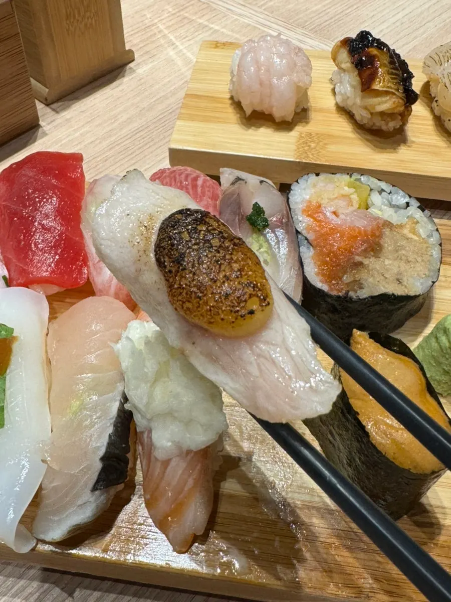Sekeping sushi dicelup ke dalam kicap tsuyu