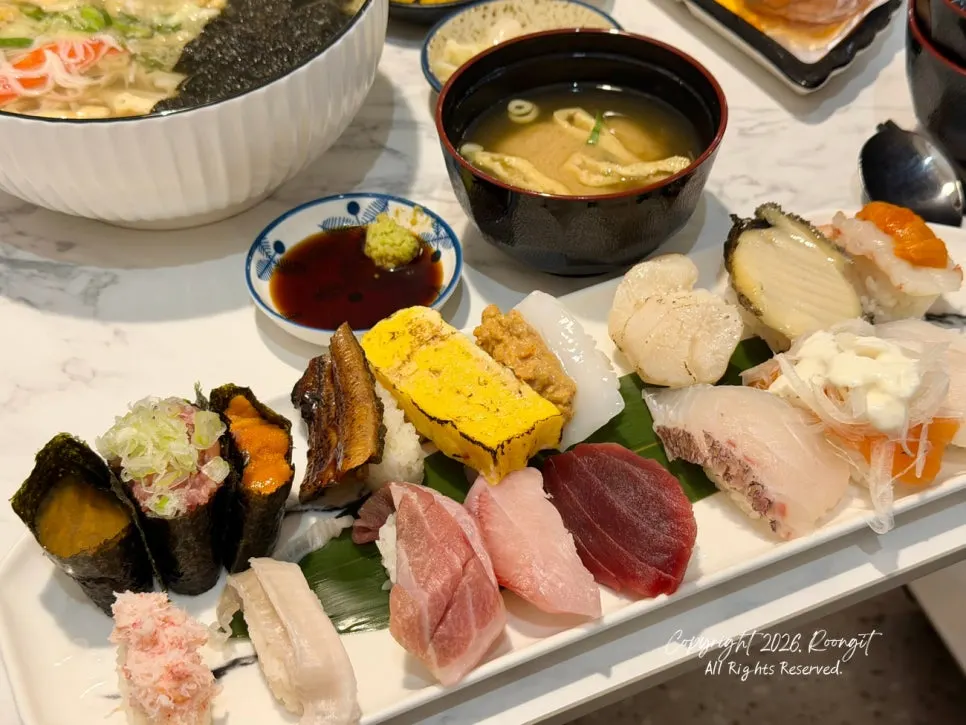 Meja dengan udon dan sushi disajikan bersamaan