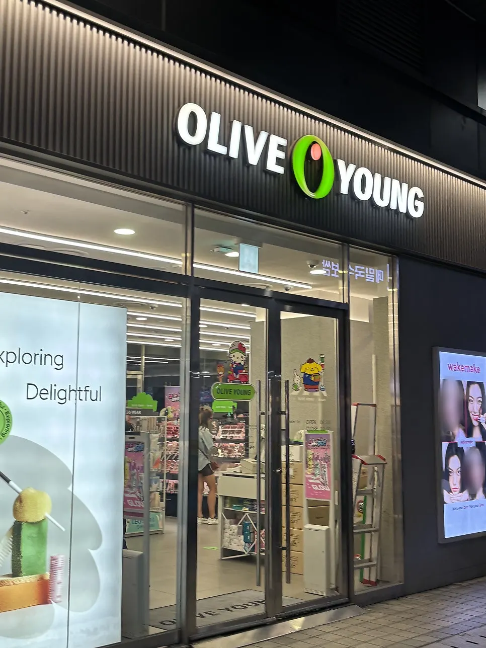 Vertical photo of the entrance to Cheonghwa Uyuk Dosakmyeon in front of Olive Young