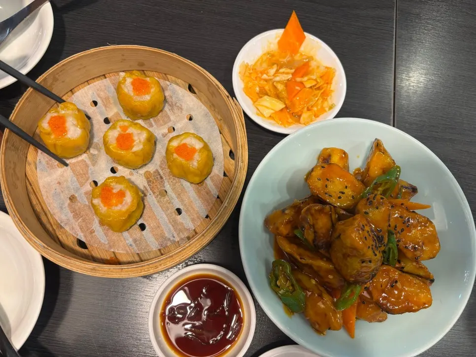 Full spread of shumai, kkwabaerou, eggplant fritters, and dosakmyeon