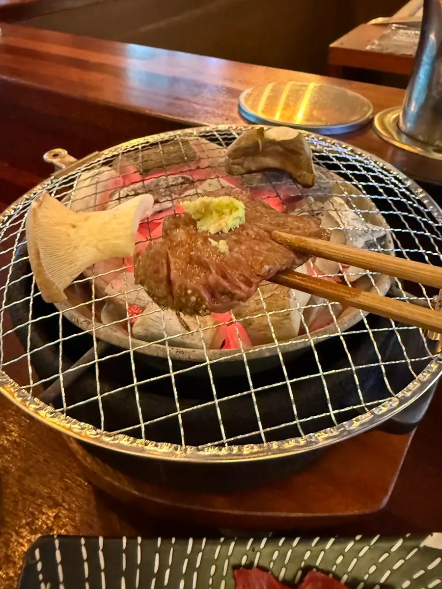 A piece of grilled beef dipped in sauce