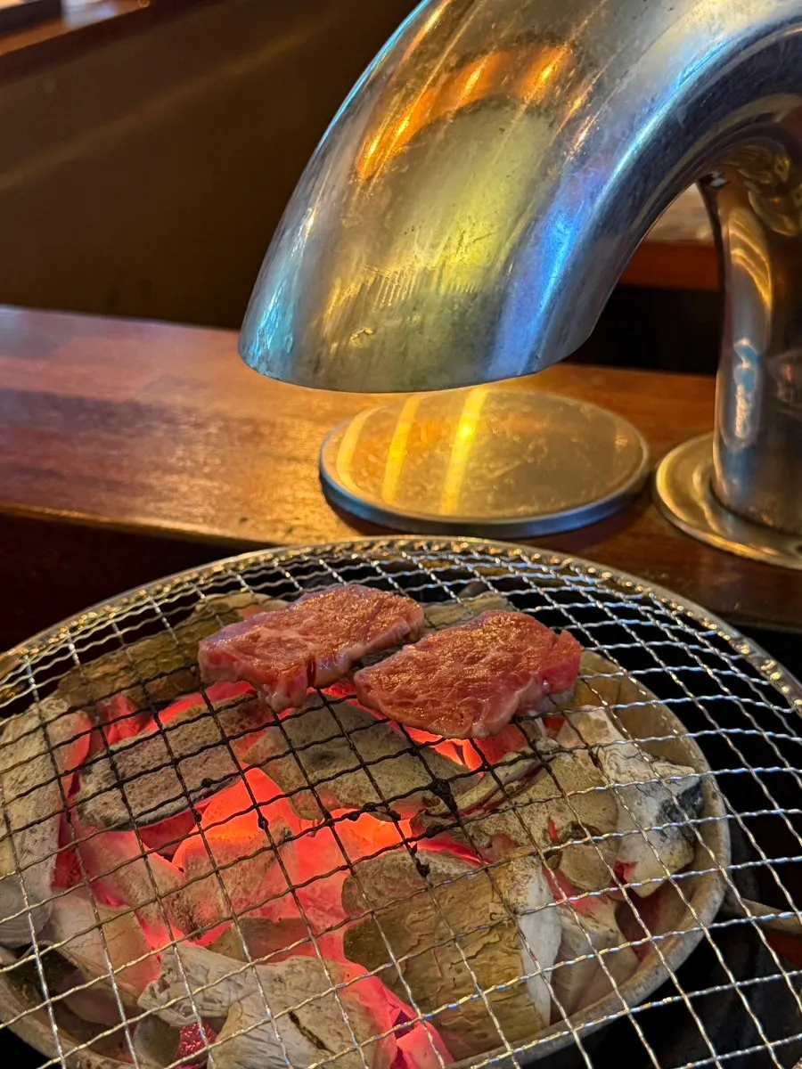Grilling meat piece by piece with tongs on the personal grill