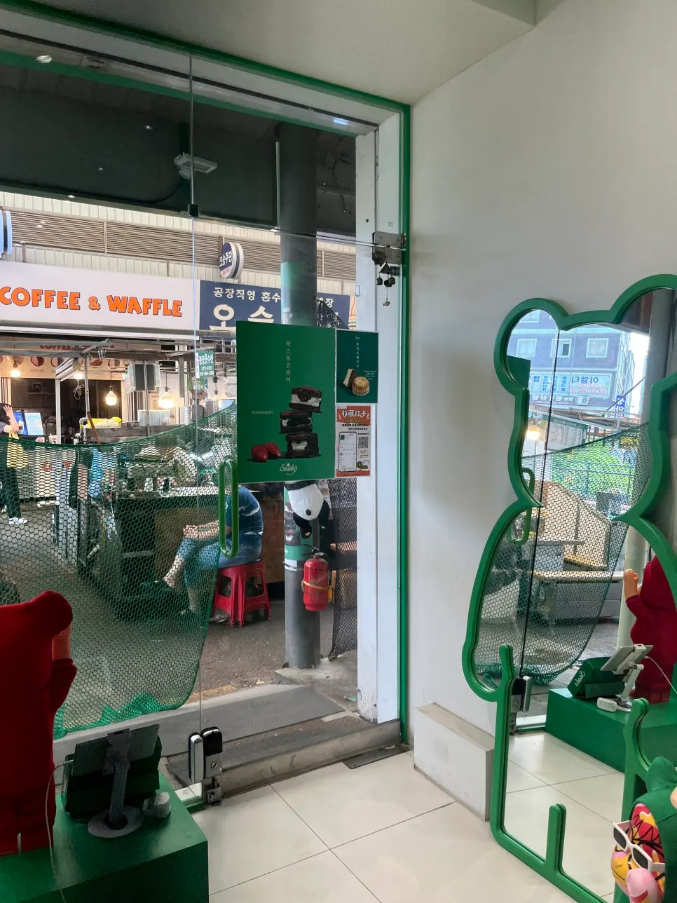 Ssuk mascot in a red outfit at the store entrance
