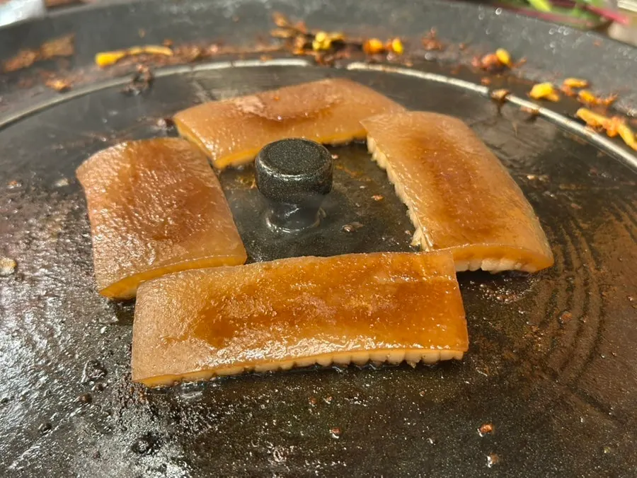 솥뚜껑에 올린 간장 껍데기