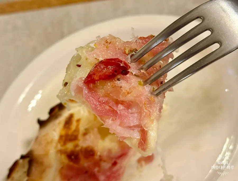 Cross-section of jambon pizza showing the chewy dough