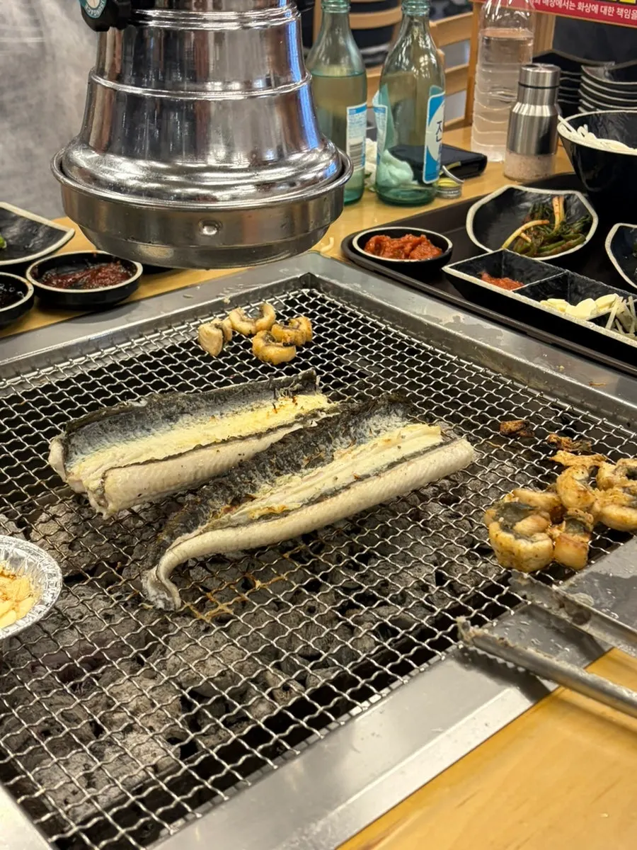 Turning eel over while grilling it at the table