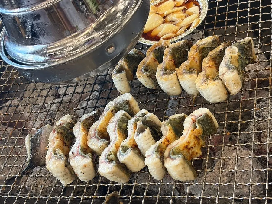 Thick eel placed over the charcoal grill