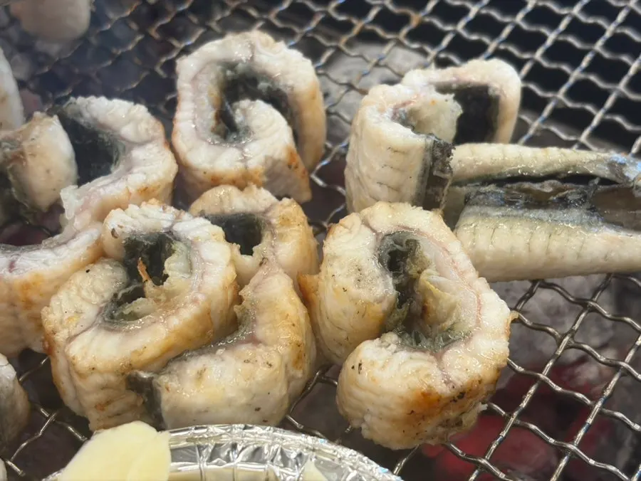 Eel turning golden brown on the grill