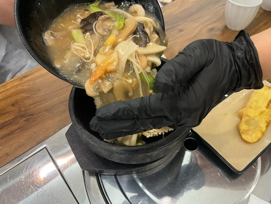 뚝배기 누룽지에 해물소스를 붓는 해물누룽지탕