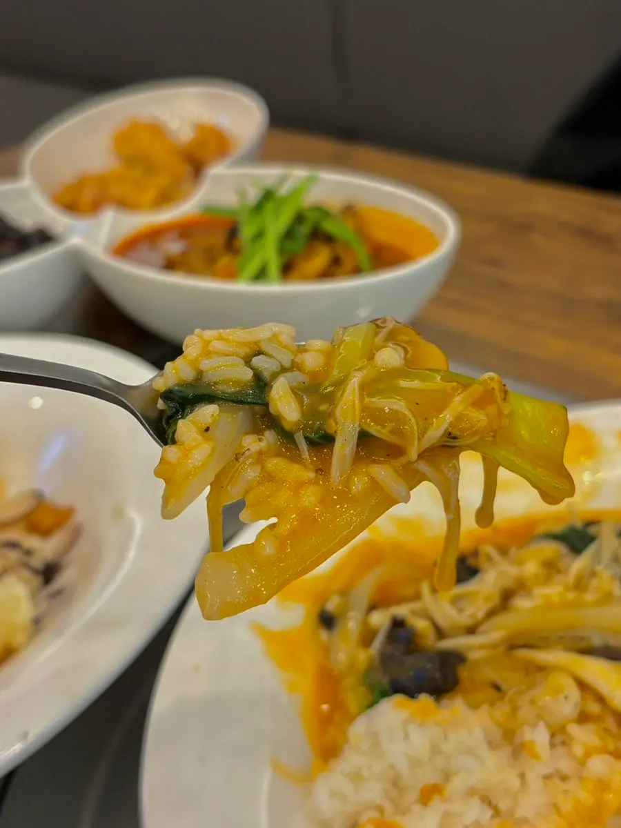 A spoonful of seafood rice bowl loaded with seafood