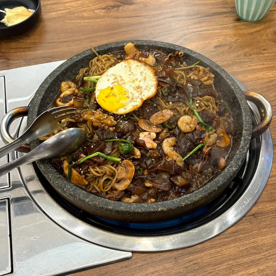 Hot stone platter jjajang loaded with seafood and ingredients