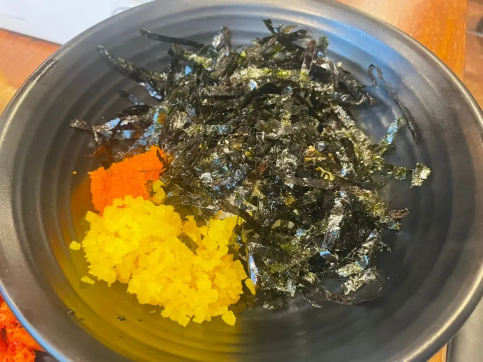 A wrap layering charcoal jokbal and spicy jokbal together