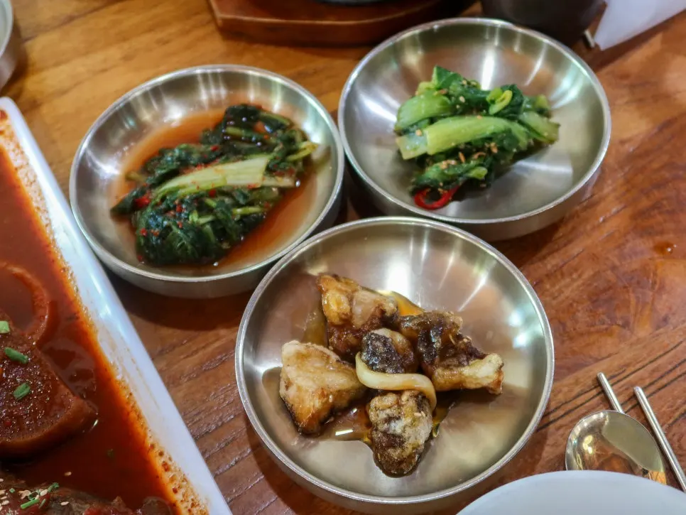 Plates of kimchi, japchae and various banchan