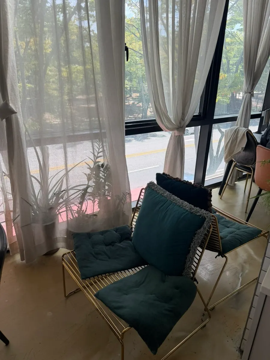 Seating area with sunlight streaming through white curtains