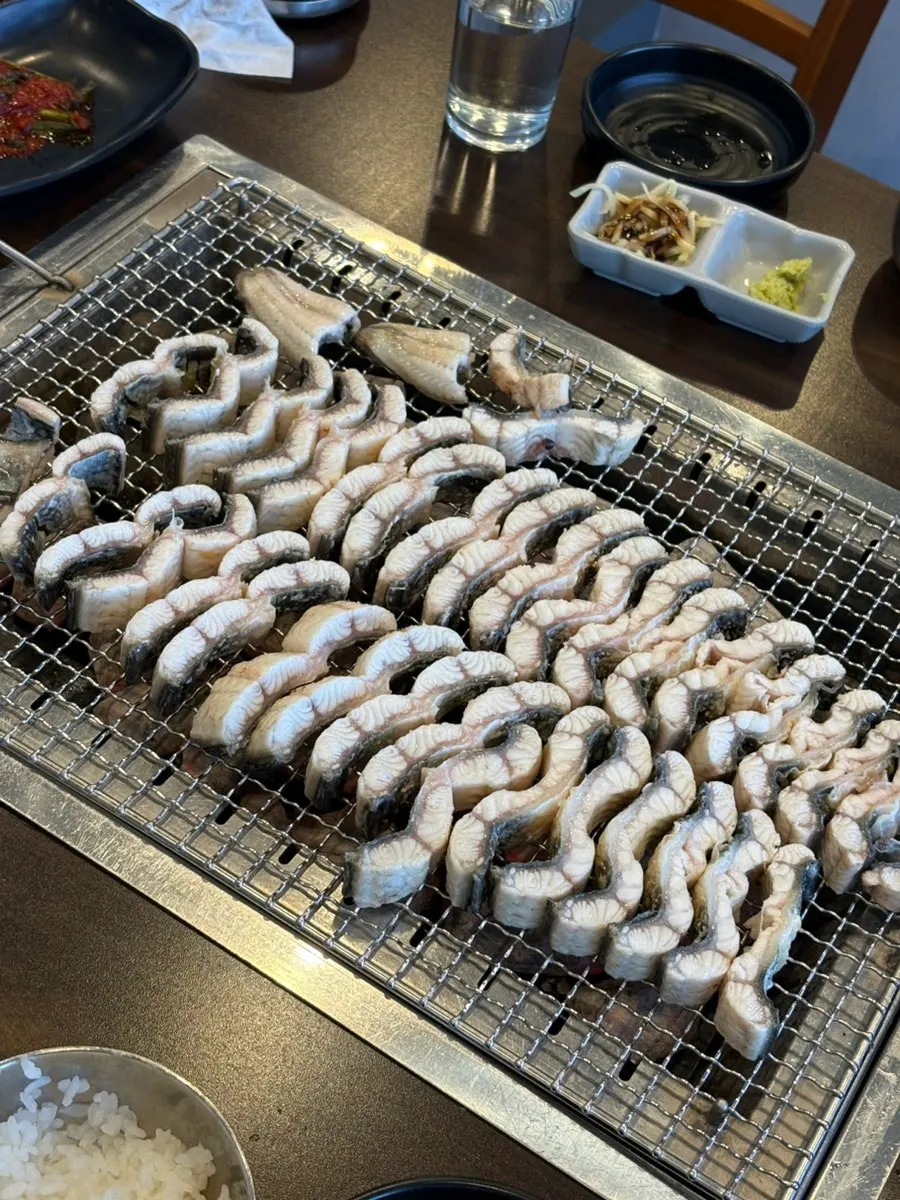 Eel grilled standing on its side over charcoal