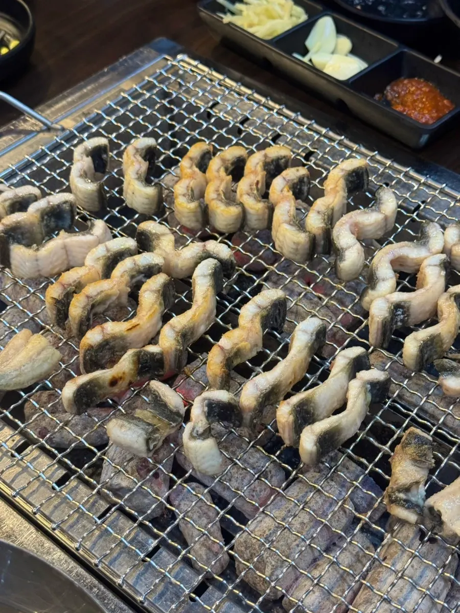 Thick eel being re-grilled over charcoal