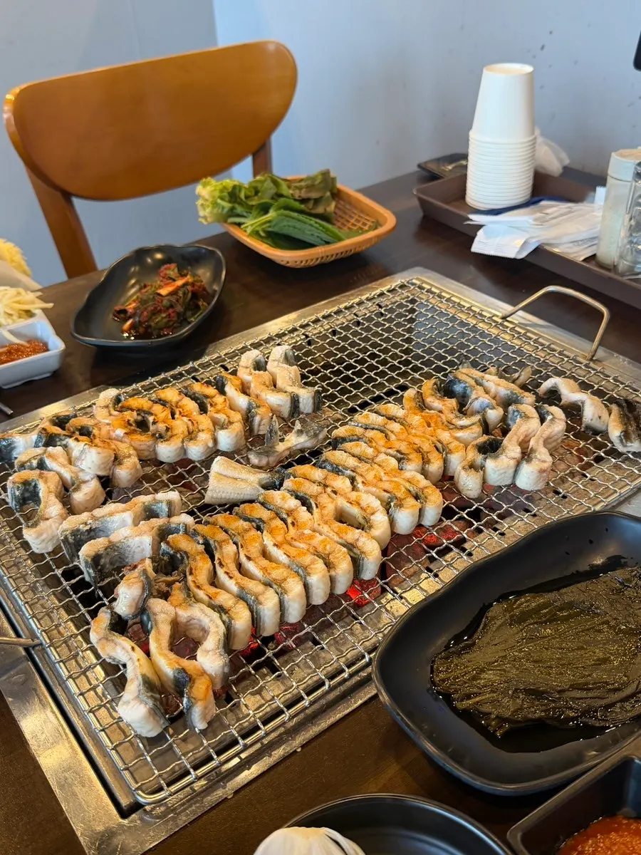 Thick freshwater eel cooking over charcoal