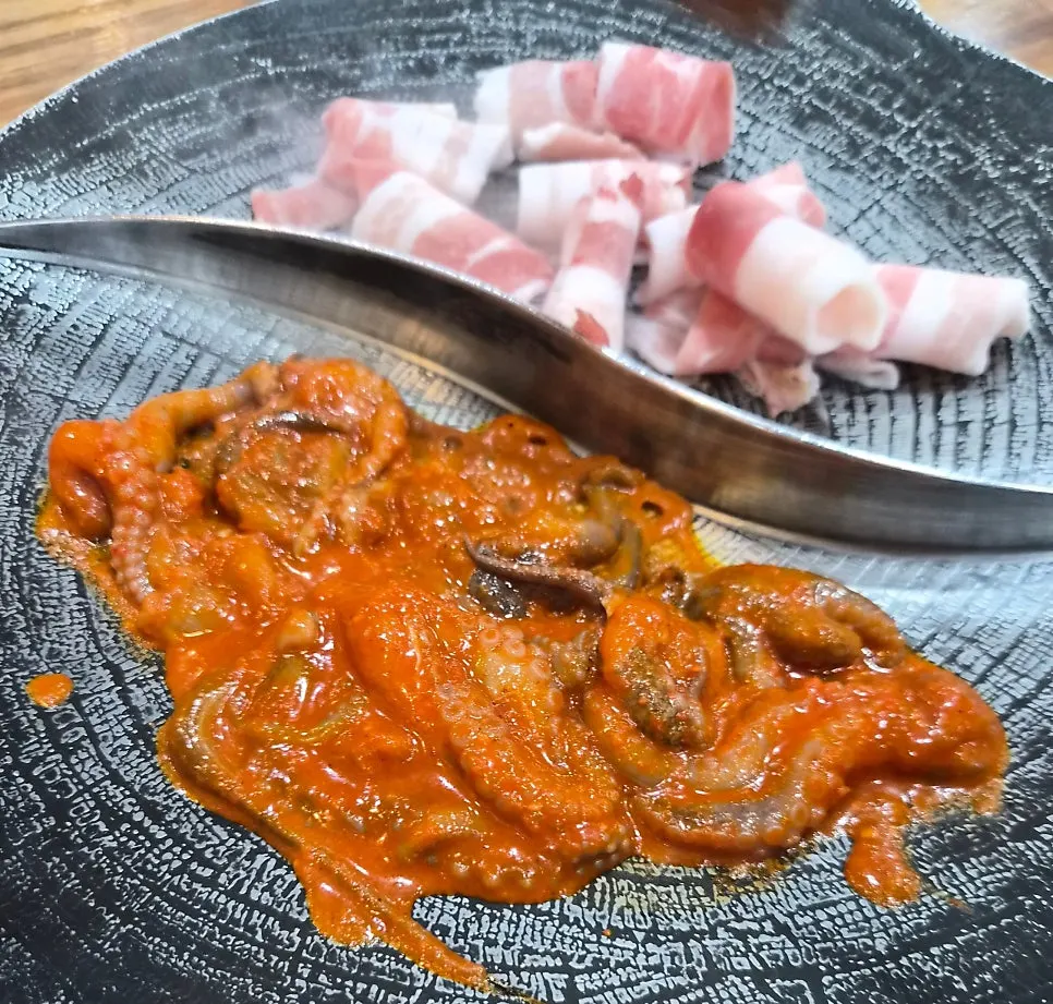 Octopus on one side of the grill and pork belly on the other