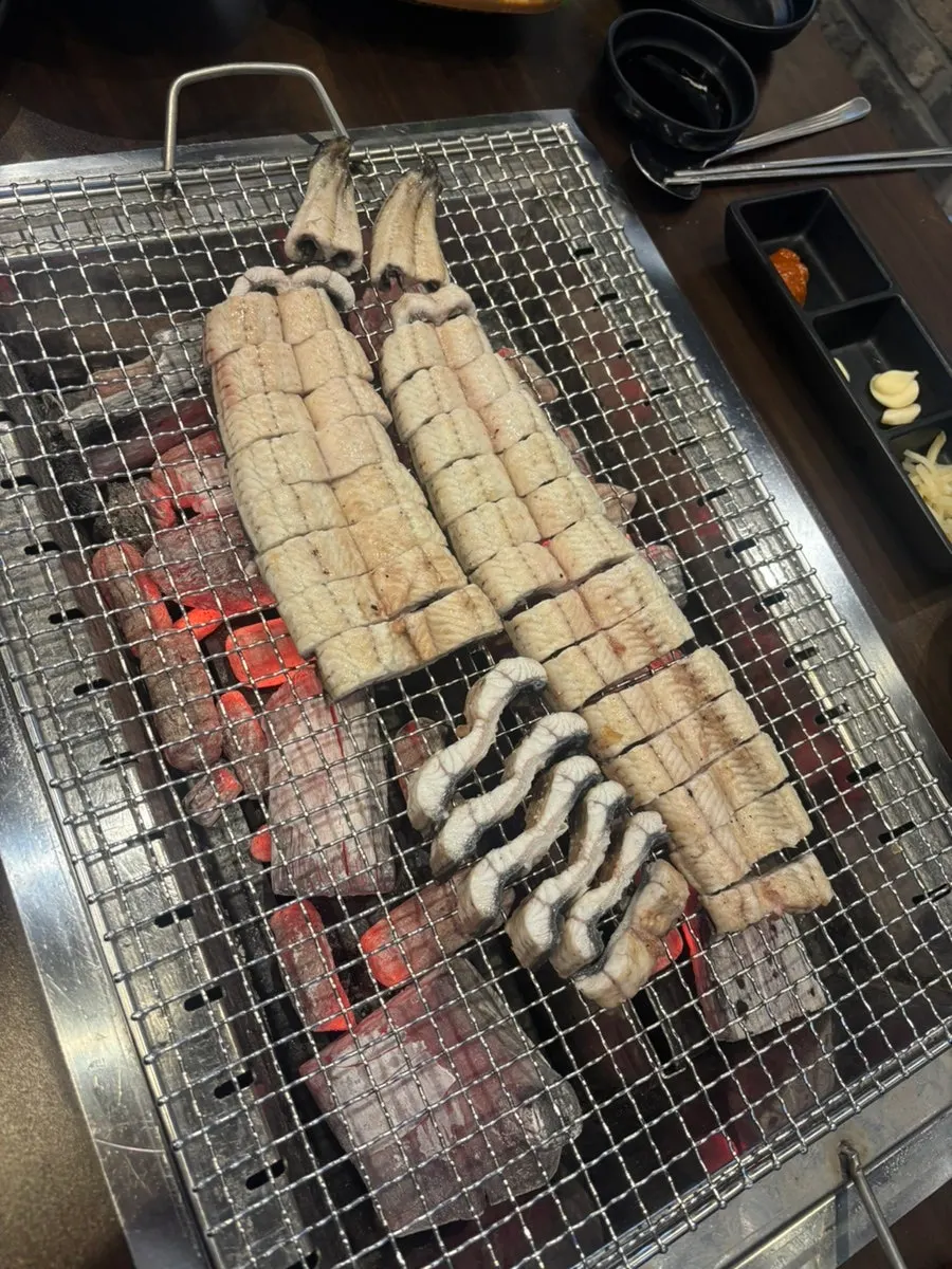 Par-grilled eel cooking over charcoal