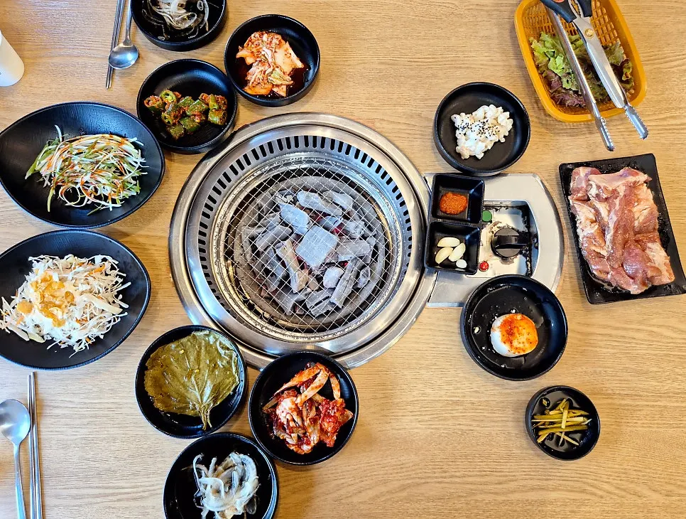 A table of ribs set with charcoal and side dishes