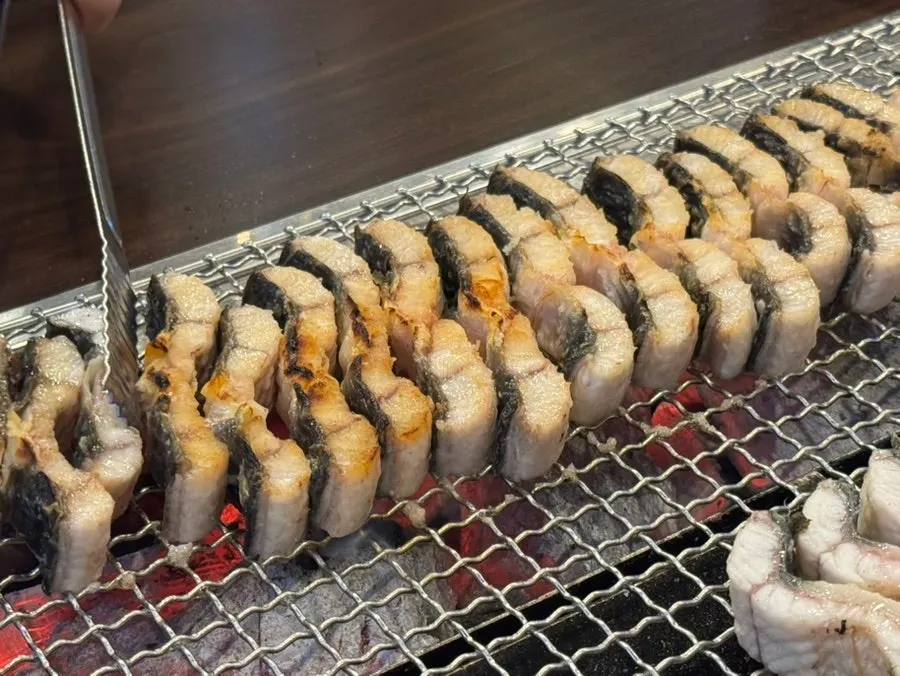 Eel pieces stood upright to grill the sides