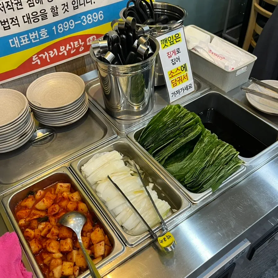 Basic side dishes: white kimchi, salted squid, diced radish kimchi, and seasoned perilla leaves