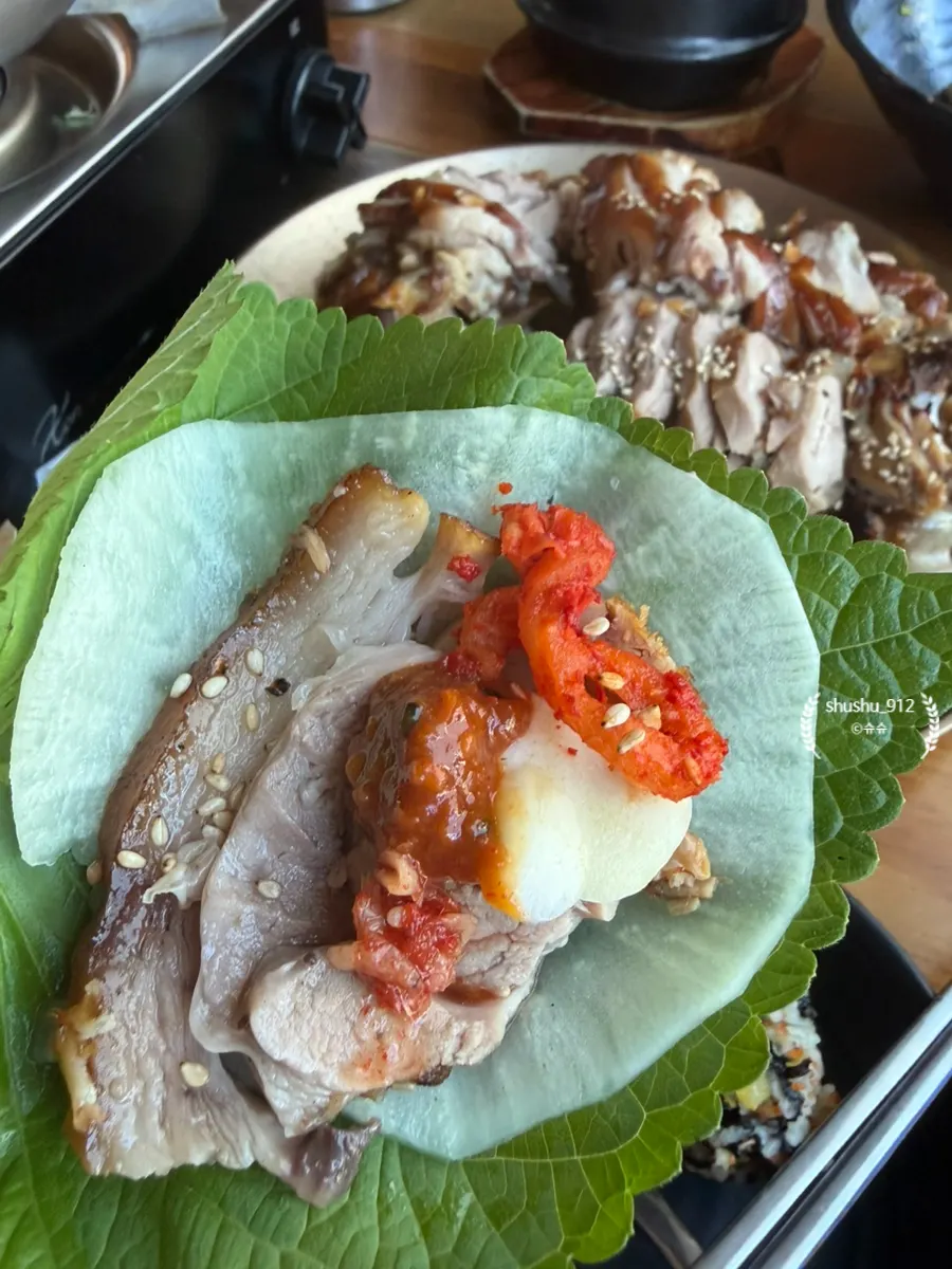 Jokbal wrap with perilla leaf and pickled radish