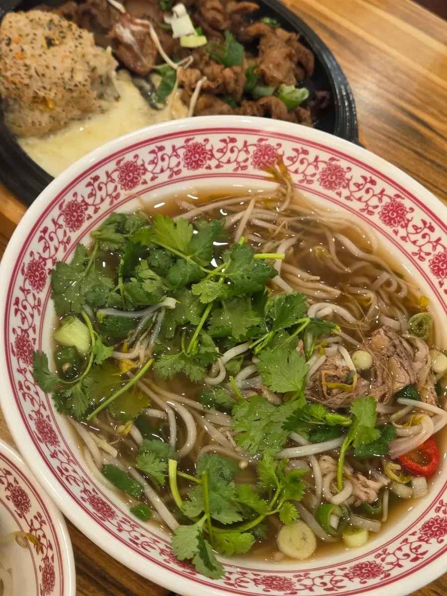 Pho topped with bean sprouts and thinly sliced meat