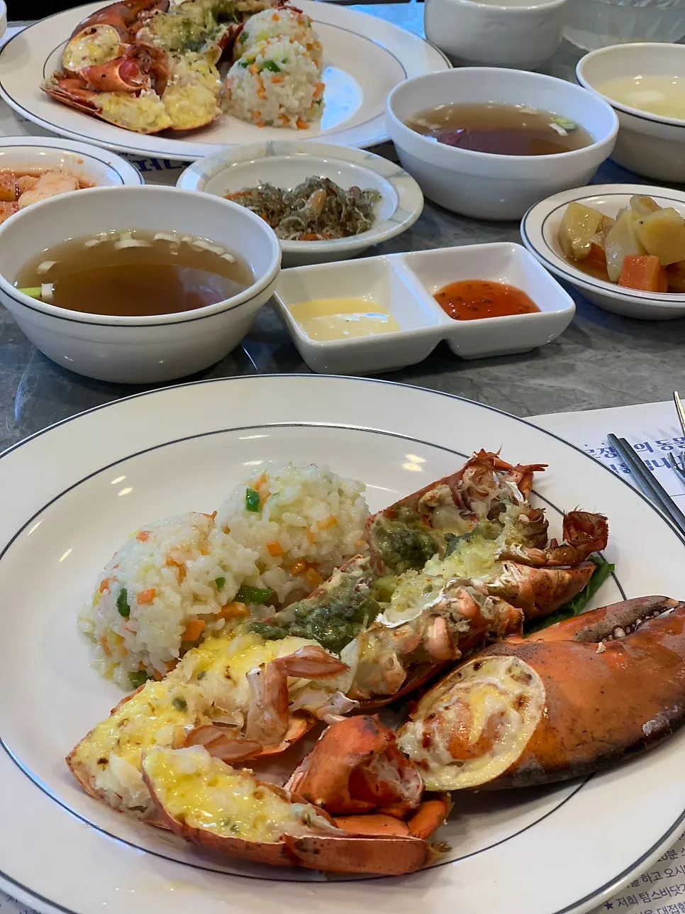 Half a seasoned grilled lobster and lobster soup