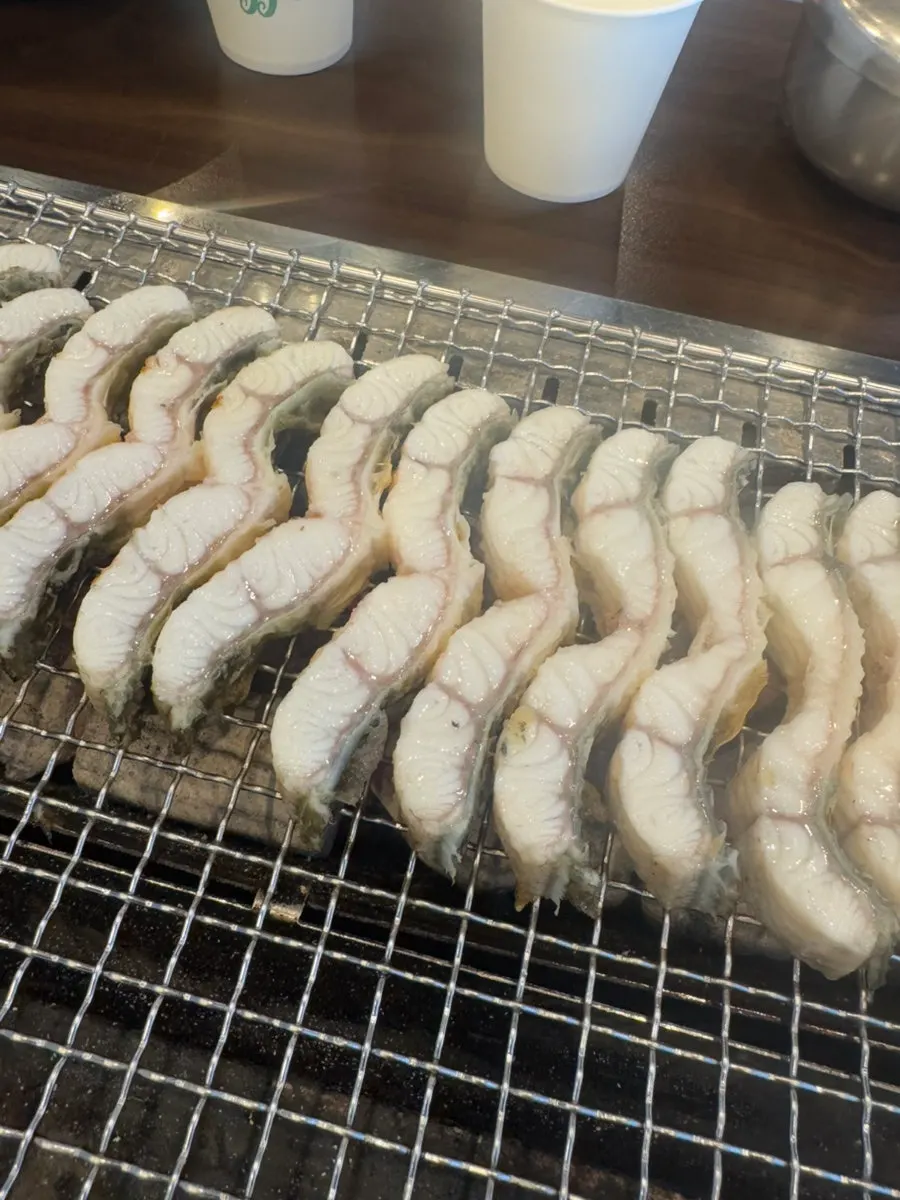 Pre-grilled eel set on the grill plate by staff