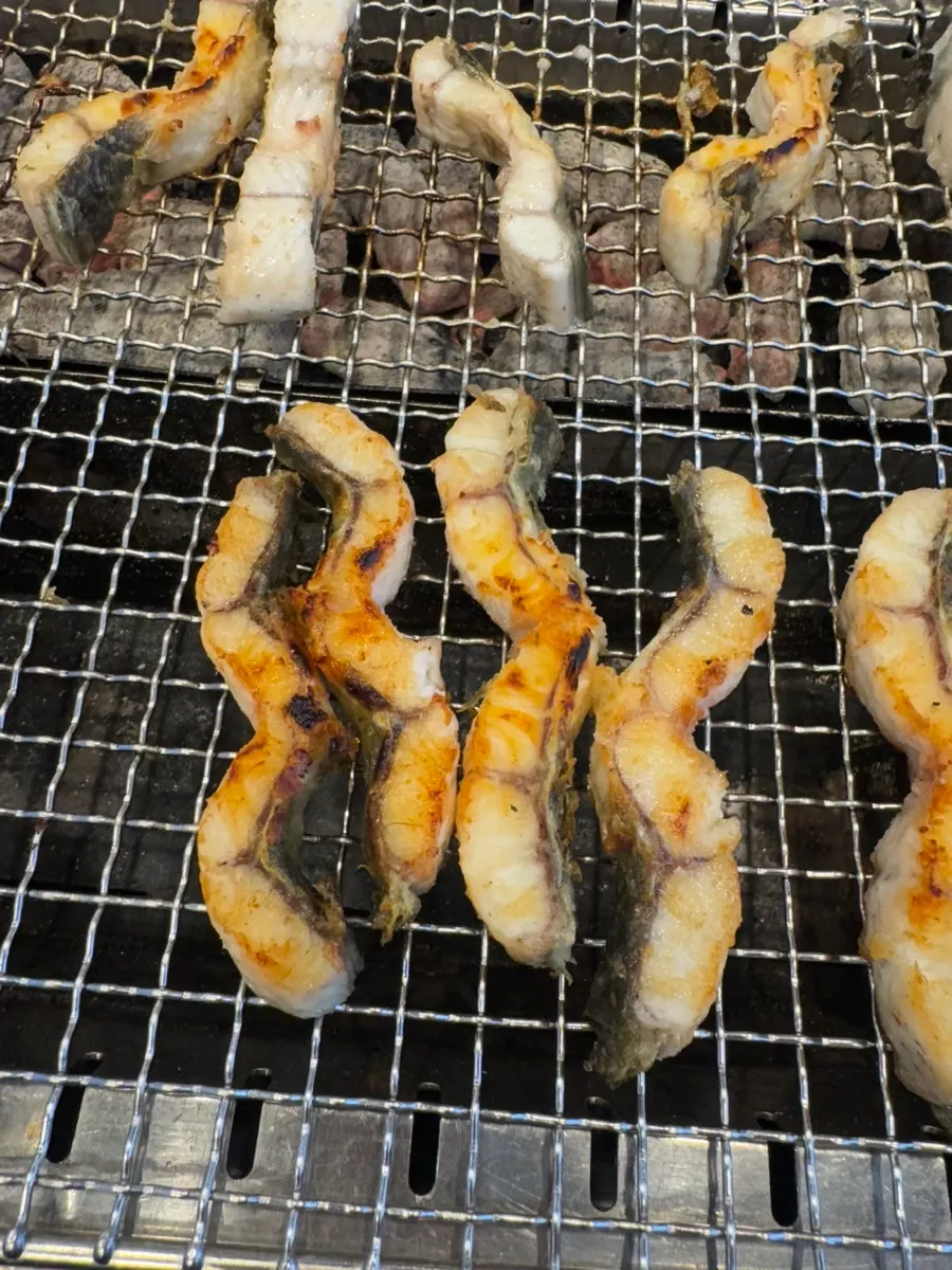 Fully grilled eel set aside on the grill plate