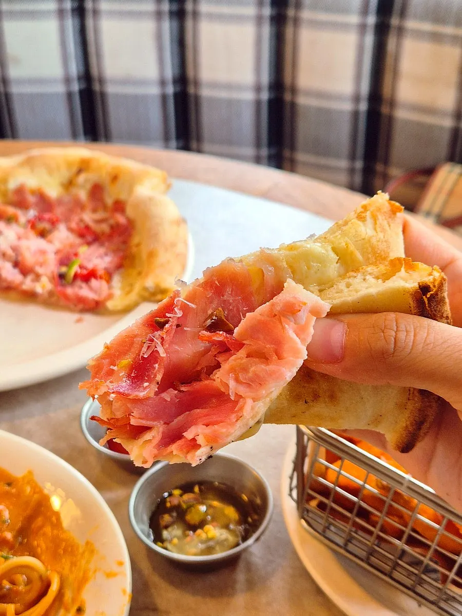 A slice of jambon pizza lifted from the pan