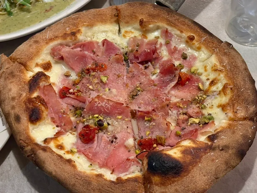 Jambon pizza topped with pistachios