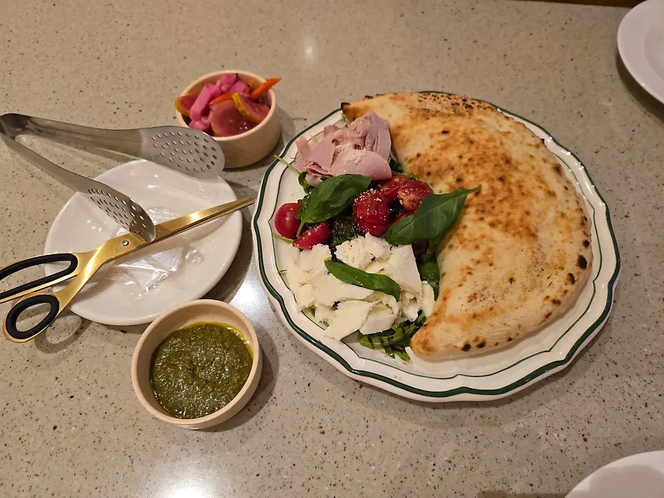 A plate of basil calzone with tomato caprese