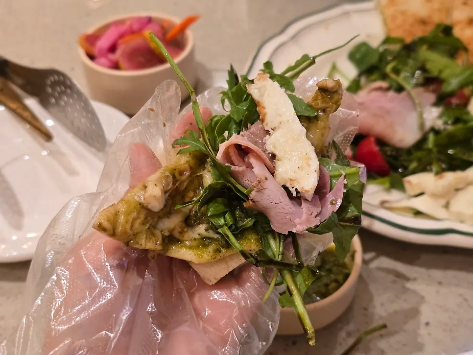 A bite of dough topped with jambon and fresh mozzarella