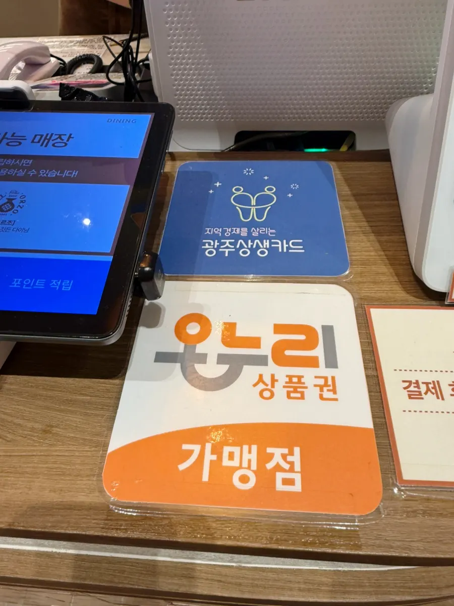 Sign noting Gwangju Sangsaeng Card and Onnuri gift certificates accepted