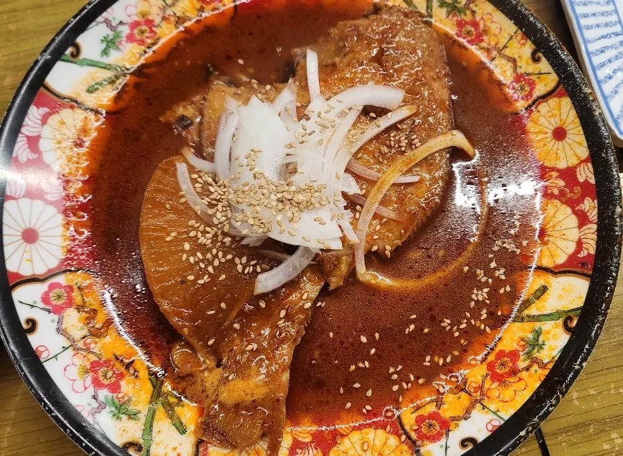 Spicy braised pomfret topped with sliced onion