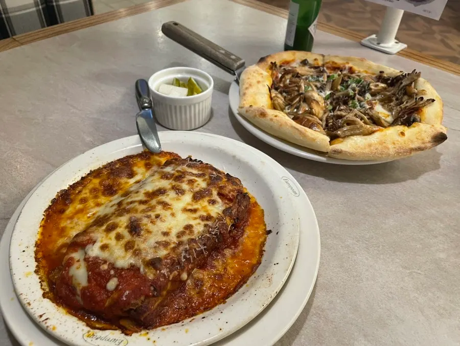 Table set with lasagna and truffle mushroom pizza