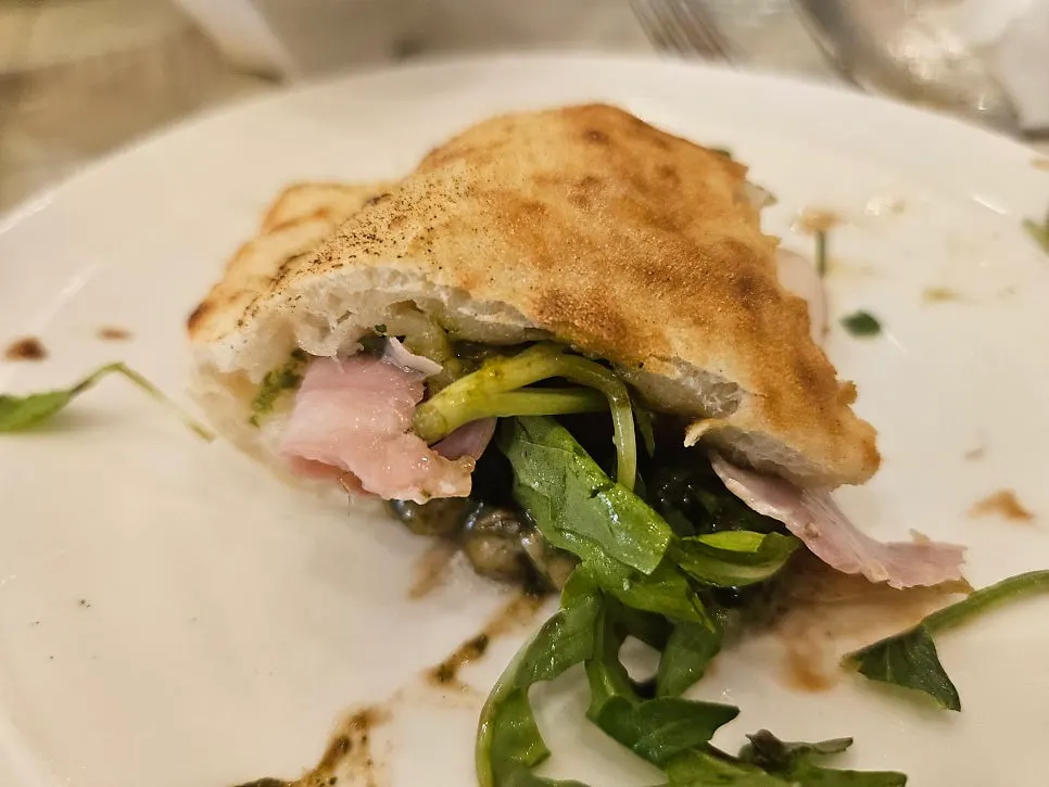 Basil calzone sliced open, revealing melted cheese